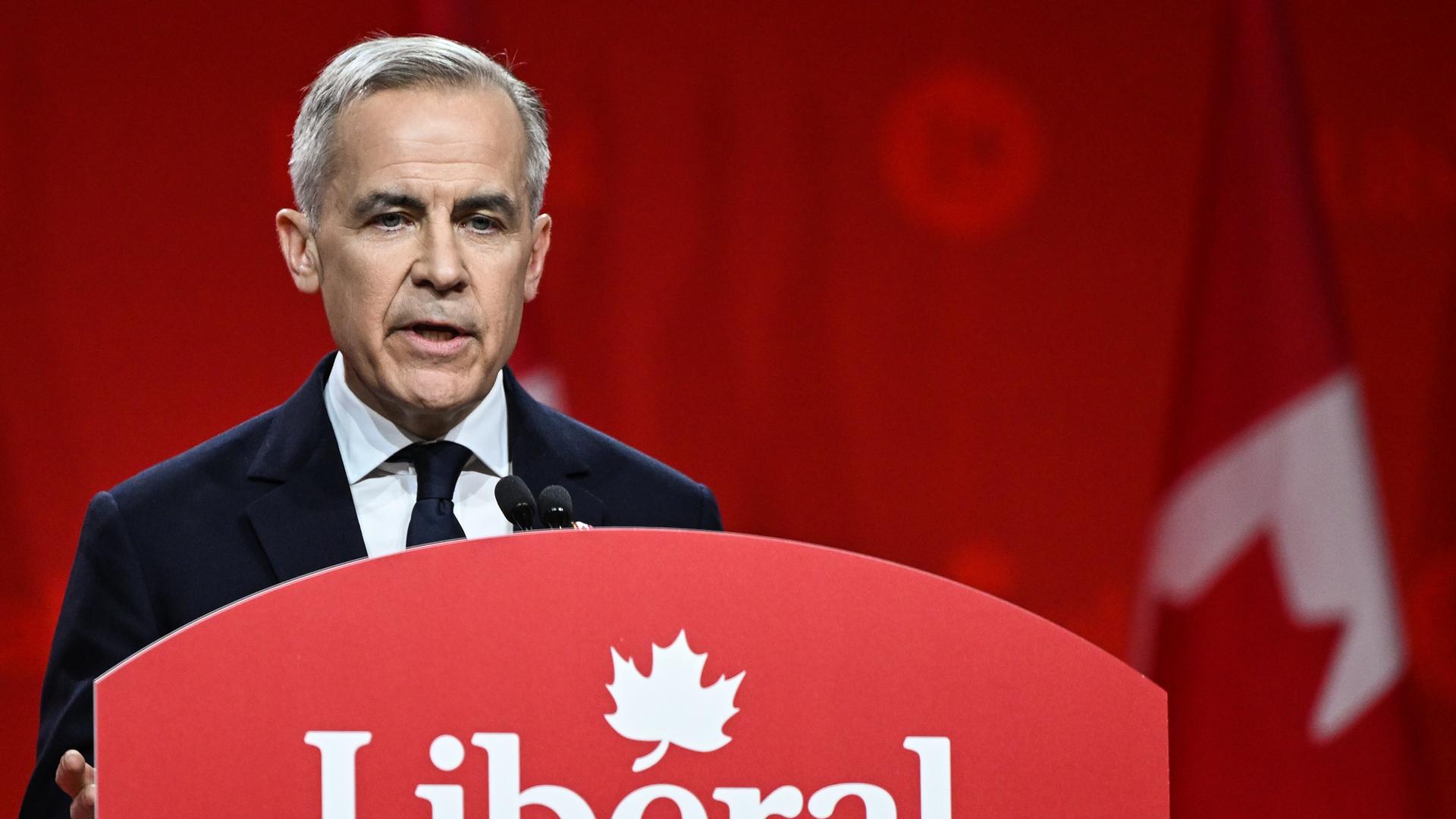 Der kanadische Premierminister Mark Carney im März 2025 in Ottawa bei einer Wahlkampfrede. Er steht an einem Rednerpult mit der Aufschrift "Liberal", dem Namen seiner Partei.