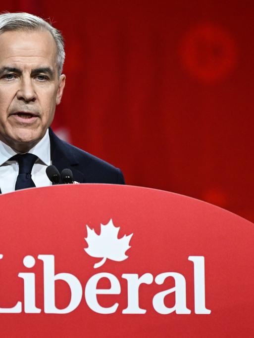 Der kanadische Premierminister Mark Carney im März 2025 in Ottawa bei einer Wahlkampfrede. Er steht an einem Rednerpult mit der Aufschrift "Liberal", dem Namen seiner Partei.