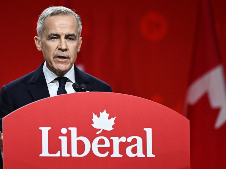 Der kanadische Premierminister Mark Carney im März 2025 in Ottawa bei einer Wahlkampfrede. Er steht an einem Rednerpult mit der Aufschrift "Liberal", dem Namen seiner Partei.