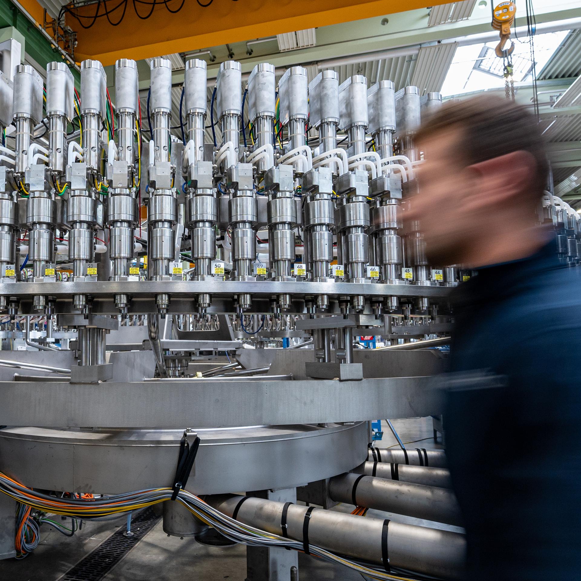 Ein Mitarbeiter geht an einer Abfüllanlage in der Produktion eines Maschinenbauunternehmens vorbei.