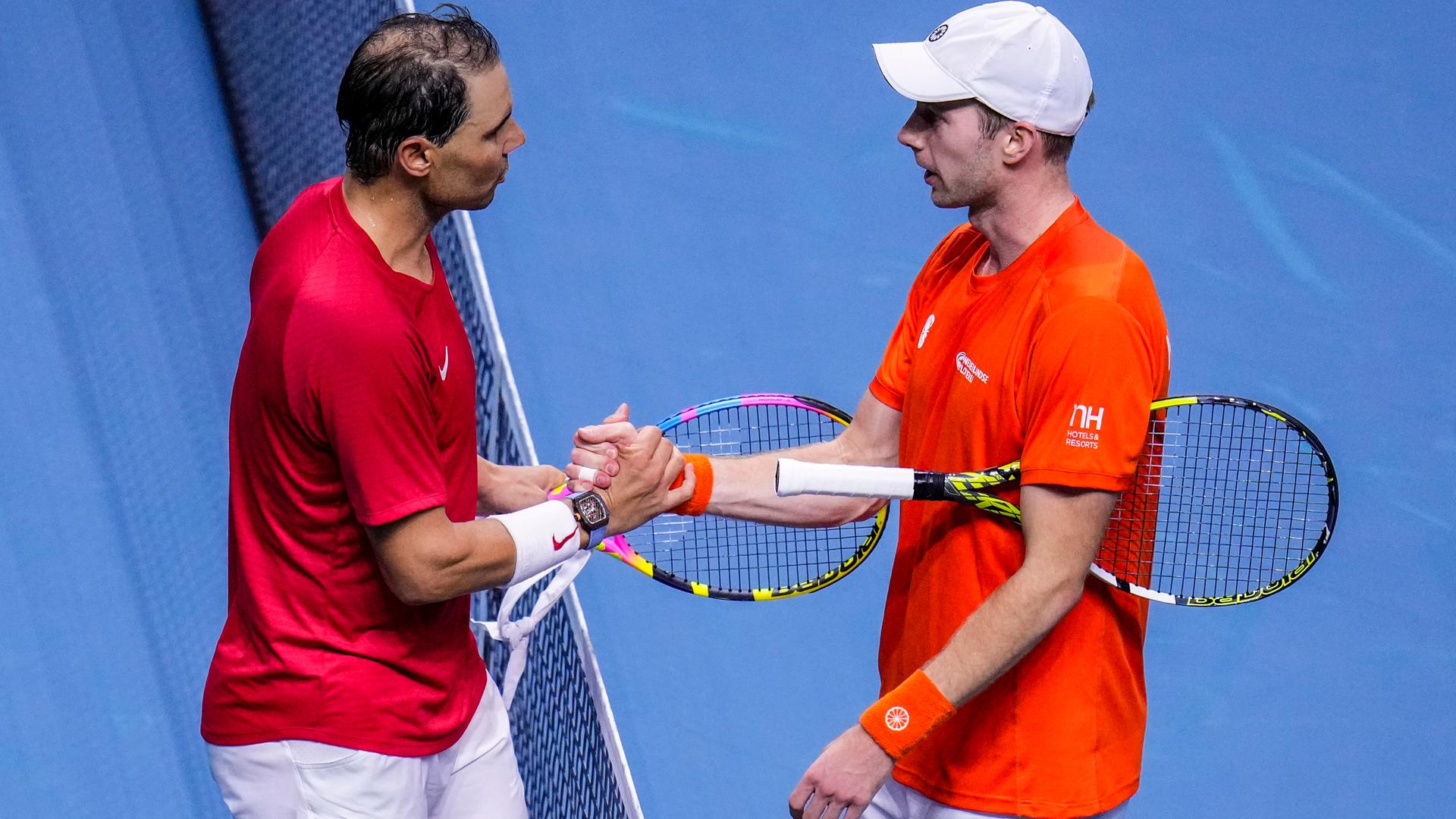 Der Spanier Rafael Nadal (l.) unterliegt dem Niederländer Botic Van De Zandschulp. Beide stehen am Netz und geben sich die Hand.