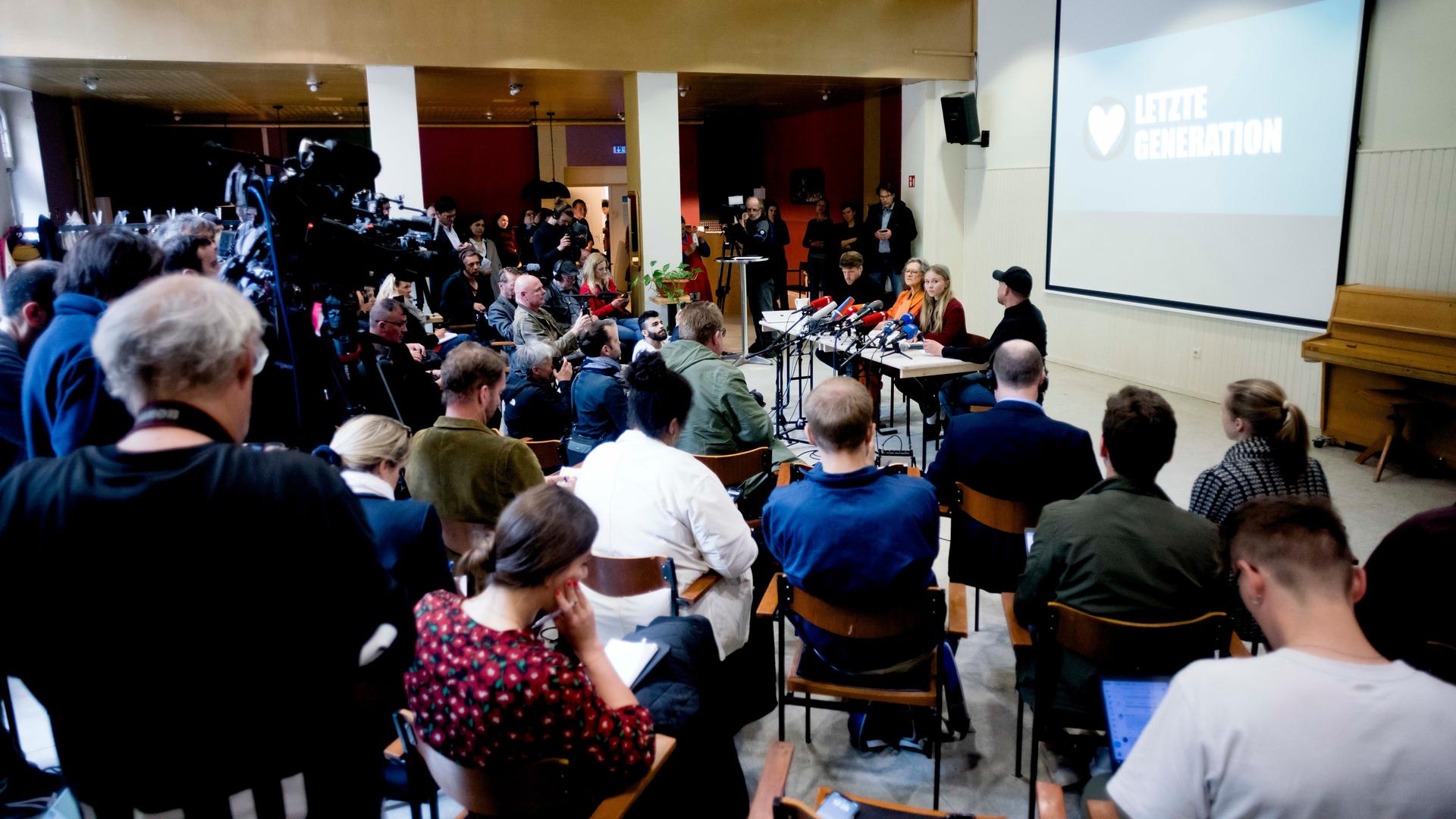 Journalisten und Mitglieder der "Letzten Generation" sitzen bei einer Pressekonferenz.