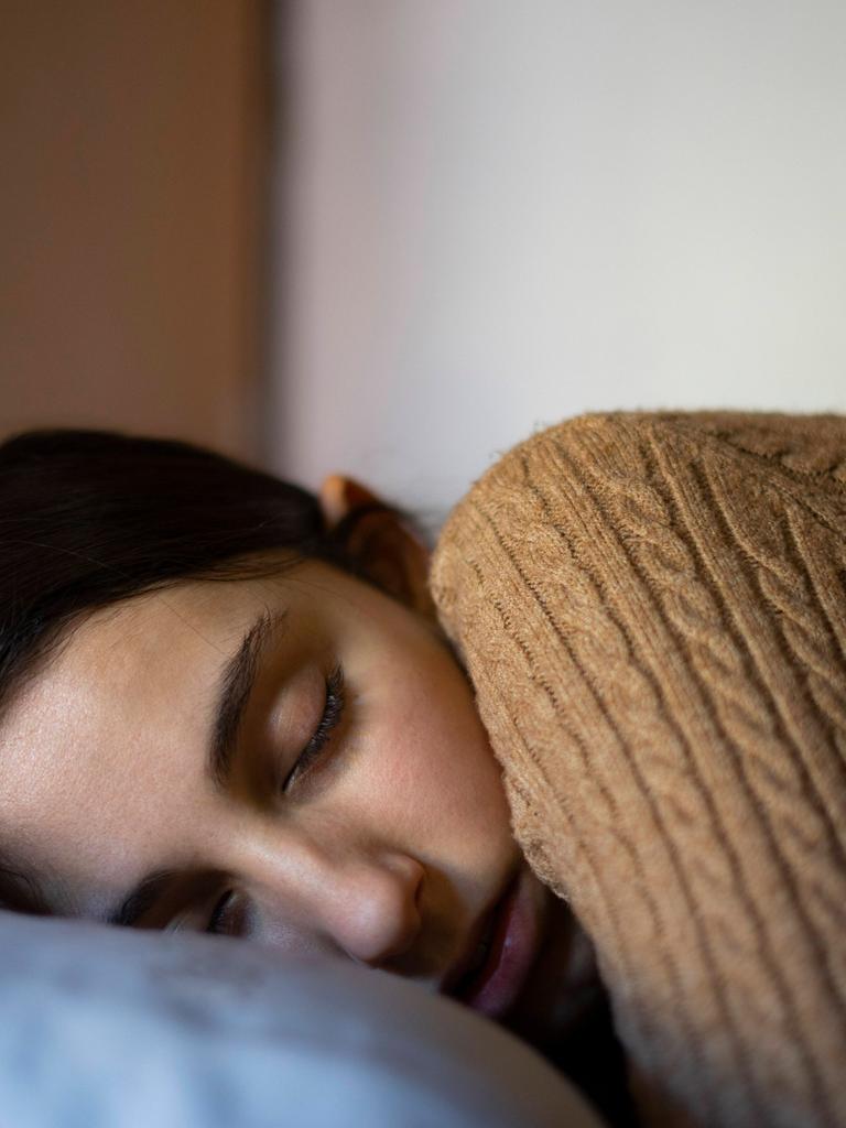 Eine junge Frau schläft im Bett.