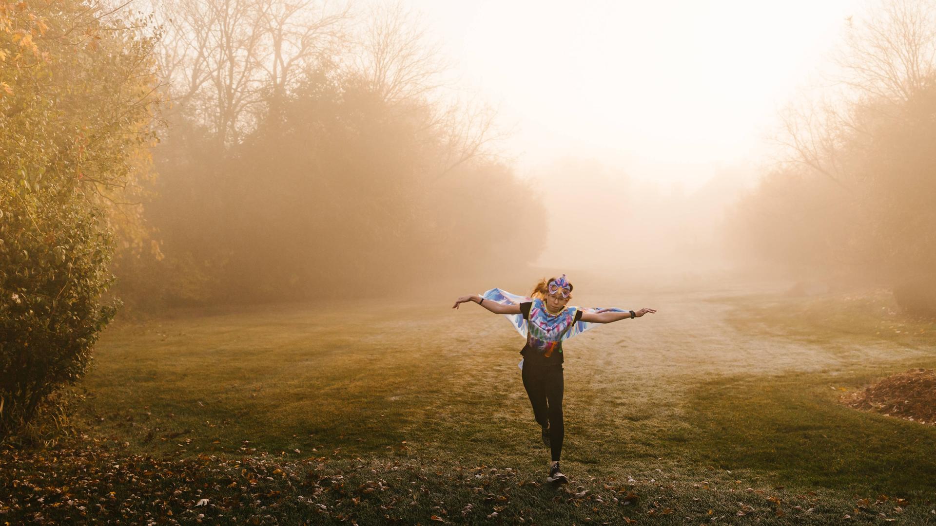 Ein Mädchen läuft als Eule verkleidet zu Halloween durch einen Park in Illinois / USA