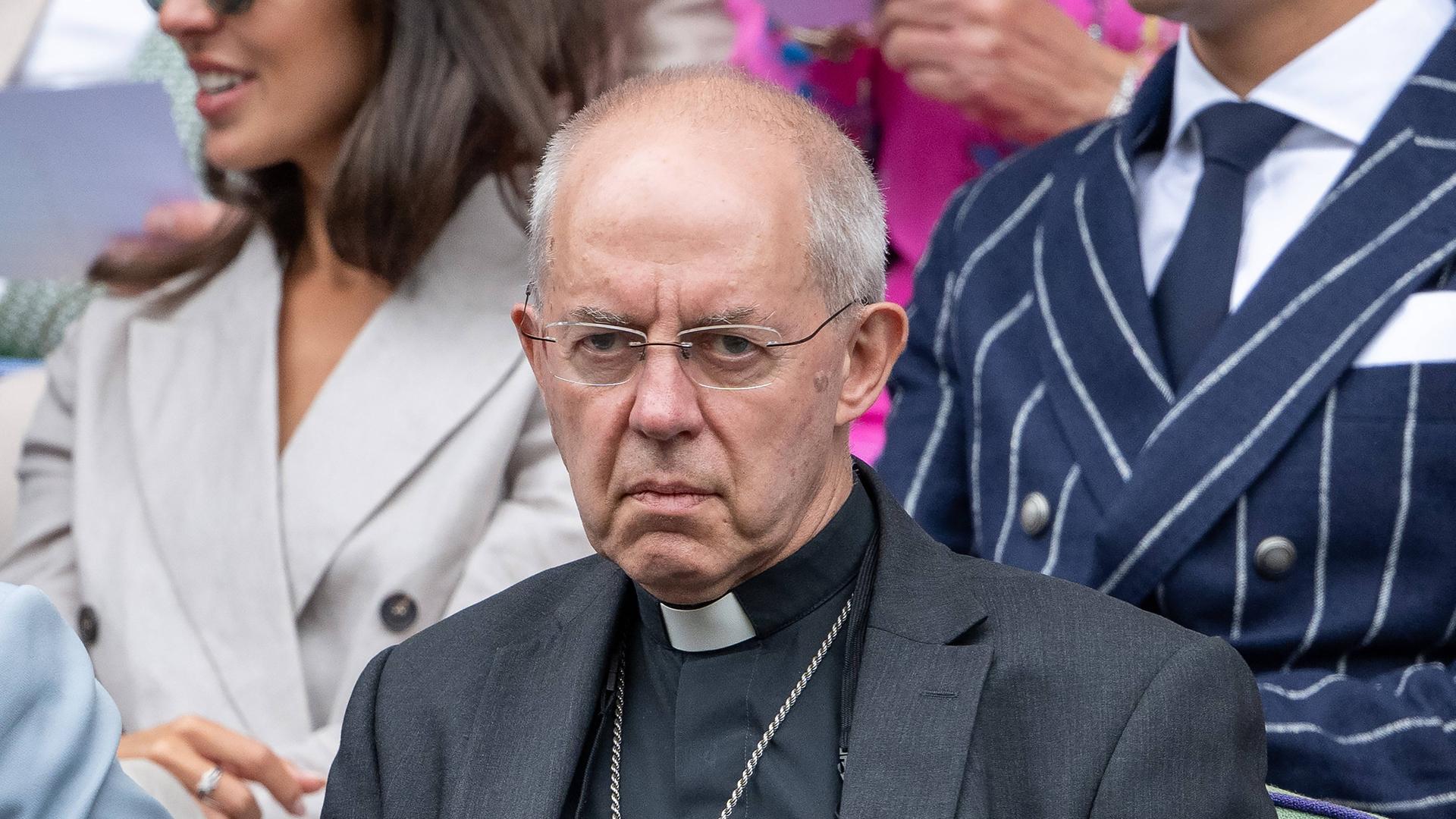 Justin Welby, Erzbischof von Canterbury sitzt beim Tennis-Turnier von Wimbledon auf der Tribüne und blickt auf den Tennisplatz. 