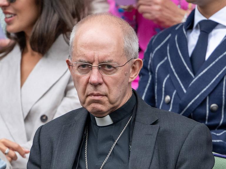 Justin Welby, Erzbischof von Canterbury sitzt beim Tennis-Turnier von Wimbledon auf der Tribüne und blickt auf den Tennisplatz. 