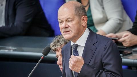 Berlin: Bundeskanzler Olaf Scholz (SPD) spricht an einem Mikrofon im Bundestag.