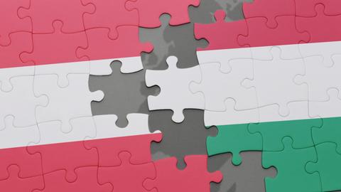 Blick auf ein Puzzle mit den Nationalflaggen von Österreich und Ungarn, die miteinander verbunden werden können. 