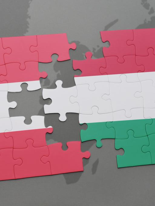Blick auf ein Puzzle mit den Nationalflaggen von Österreich und Ungarn, die miteinander verbunden werden können. 