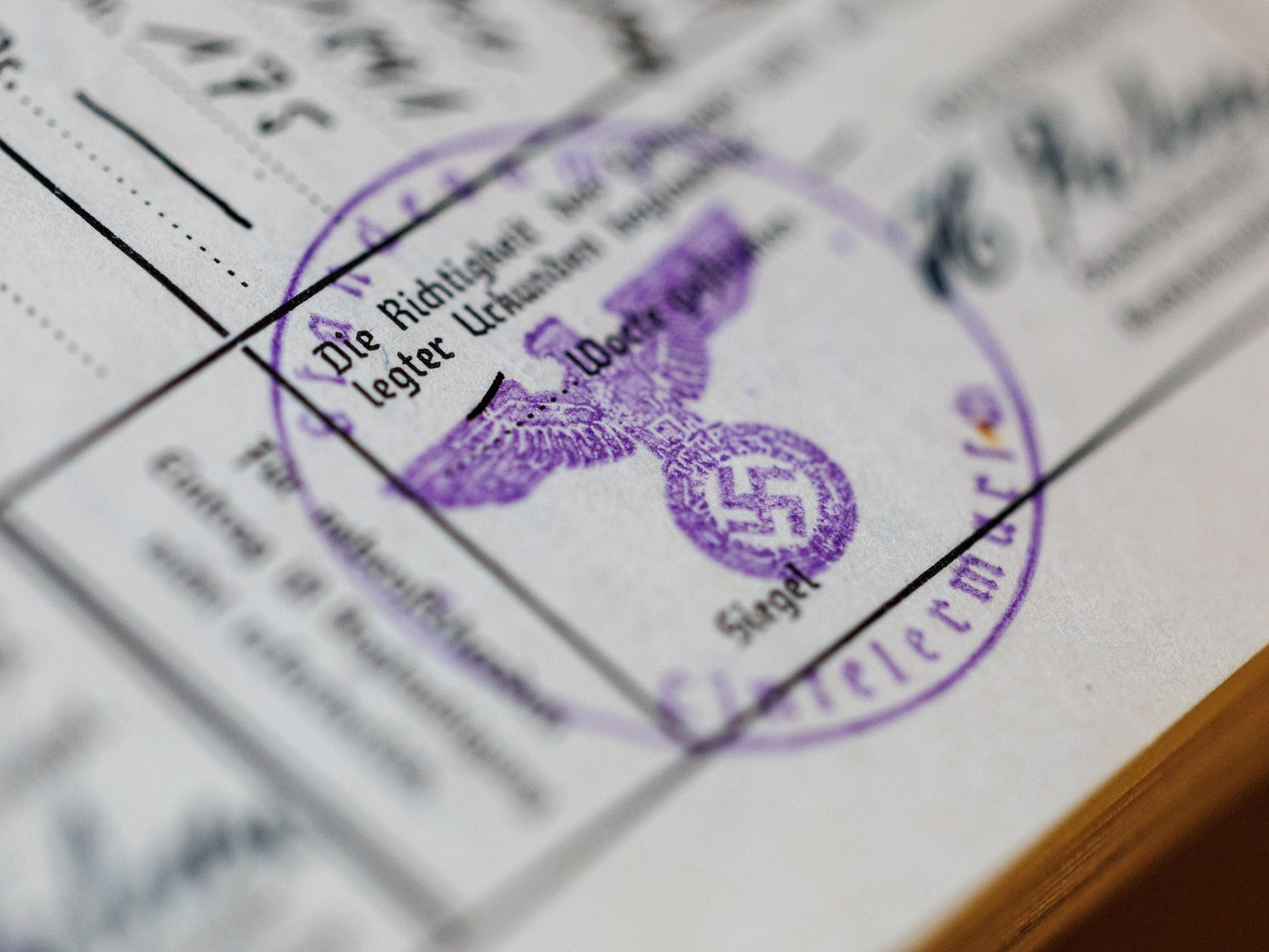 Ein Siegelstempel mit dem Parteiadler mit Hakenkreuz ist in einem Ahnenpass aus dem dritten Reich zu sehen. 