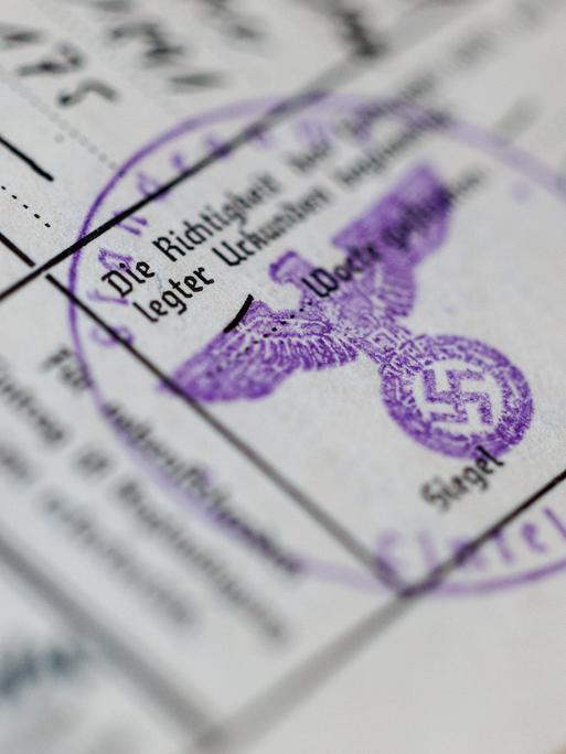 Ein Siegelstempel mit dem Parteiadler mit Hakenkreuz ist in einem Ahnenpass aus dem dritten Reich zu sehen. 
