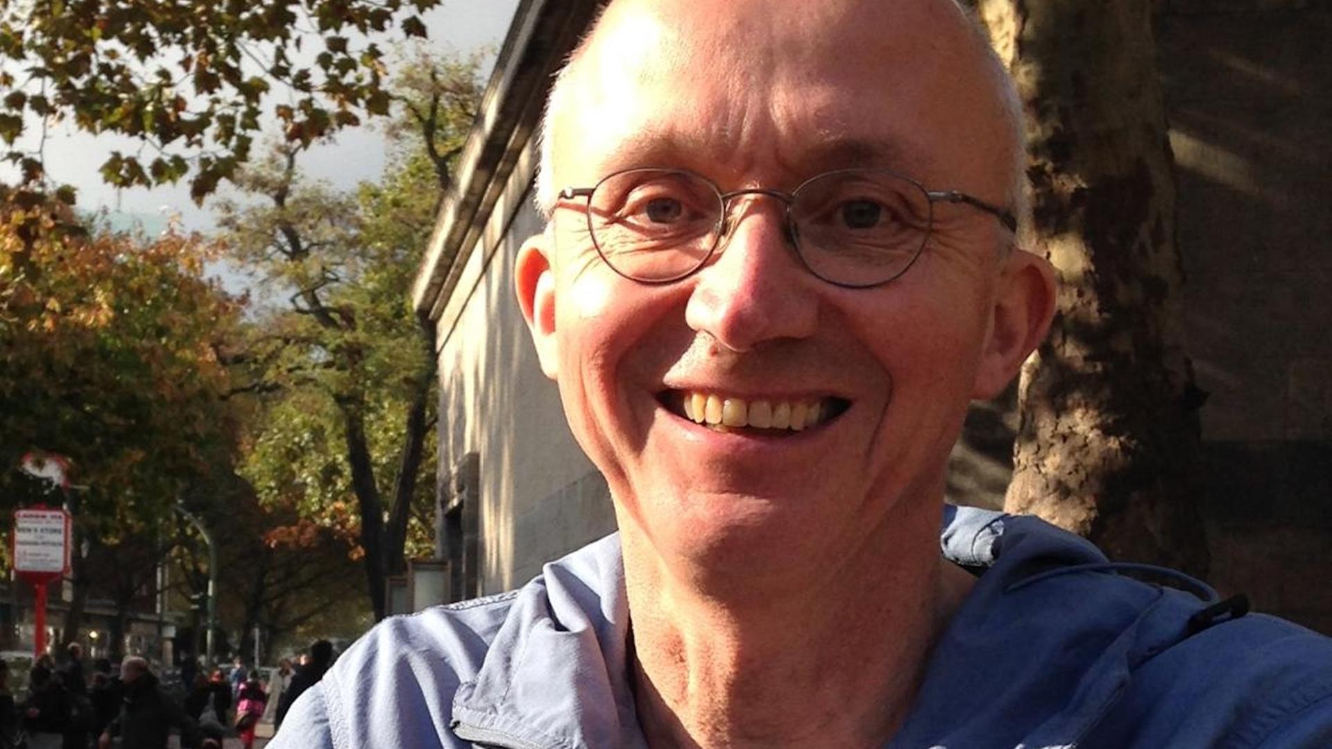 Georg Witte lacht in die Kamera. Er trägt eine randlose Brille und sehr kurzes, helles Haar.