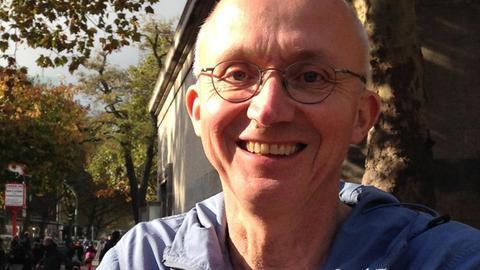 Georg Witte lacht in die Kamera. Er trägt eine randlose Brille und sehr kurzes, helles Haar.