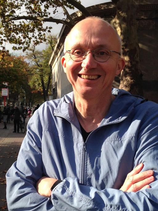 Georg Witte lacht in die Kamera. Er trägt eine randlose Brille und sehr kurzes, helles Haar.