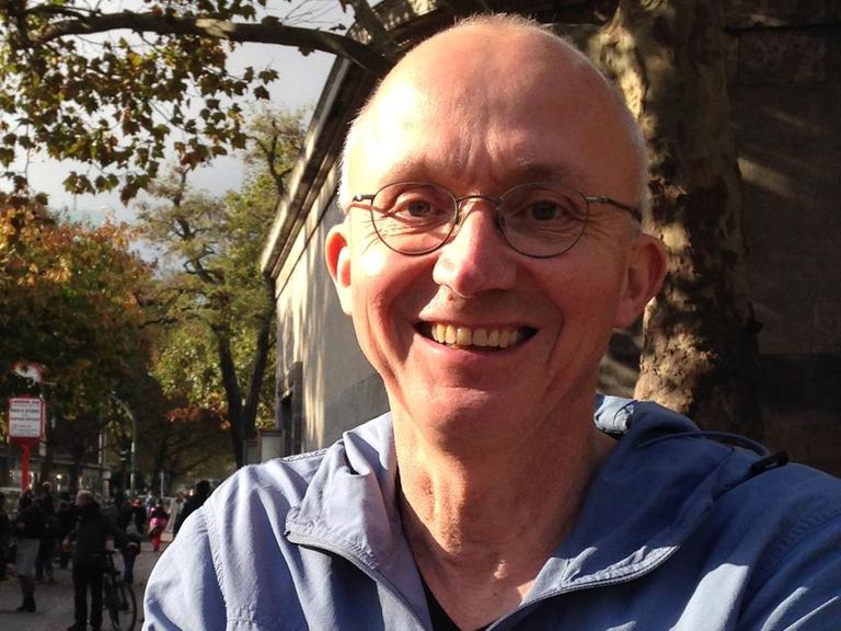 Georg Witte lacht in die Kamera. Er trägt eine randlose Brille und sehr kurzes, helles Haar.