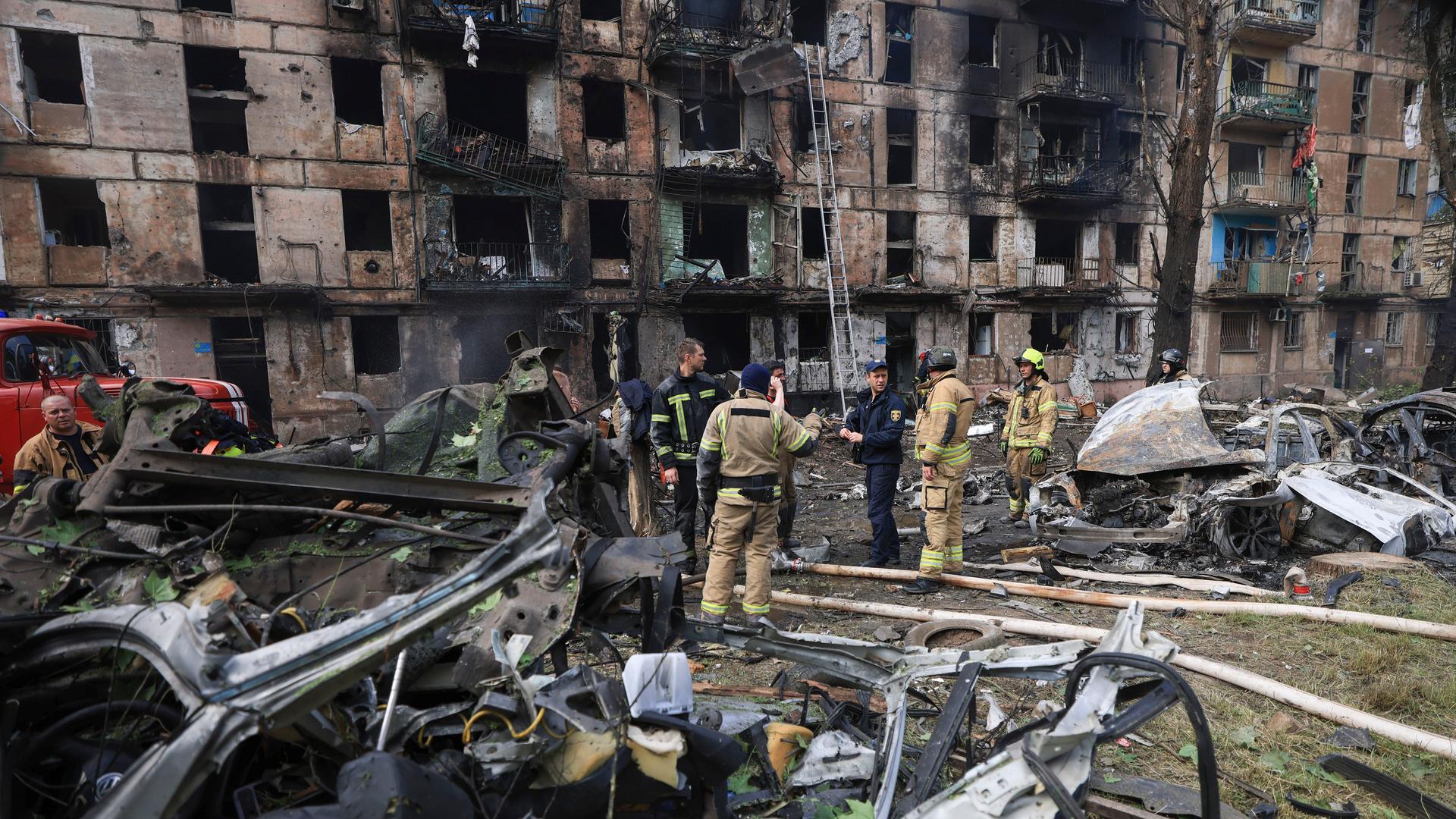 Zerstörungen in der Stadt Krywyj Rih durch einen russischen Angriff im vergangenen Sommer. Rettungskräfte inspizieren ein beschädigtes mehrstöckiges Wohnhaus.