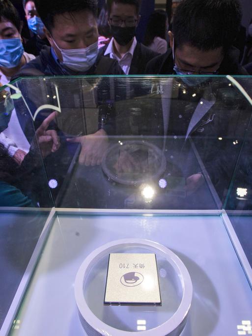Besucher schauen sich auf dem jährlichen Cloud-Service-Technologieforum, das von der Alibaba Group in Hangzhou in der ostchinesischen Provinz Zhejiang veranstaltet wird, einen Serverprozessor an