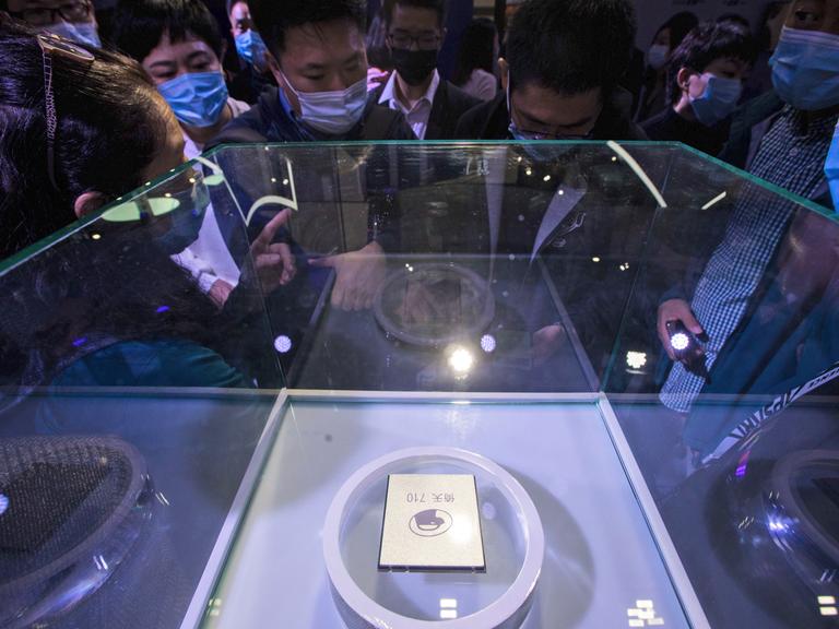 Besucher schauen sich auf dem jährlichen Cloud-Service-Technologieforum, das von der Alibaba Group in Hangzhou in der ostchinesischen Provinz Zhejiang veranstaltet wird, einen Serverprozessor an