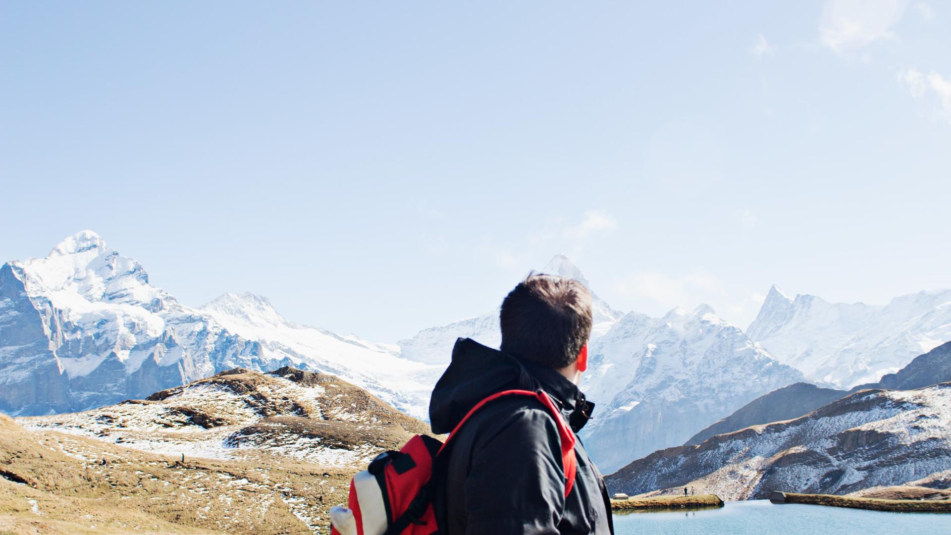 Mann schaut auf die Alpen.
