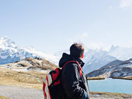 Mann schaut auf die Alpen.