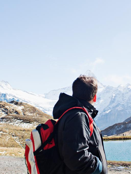 Mann schaut auf die Alpen.