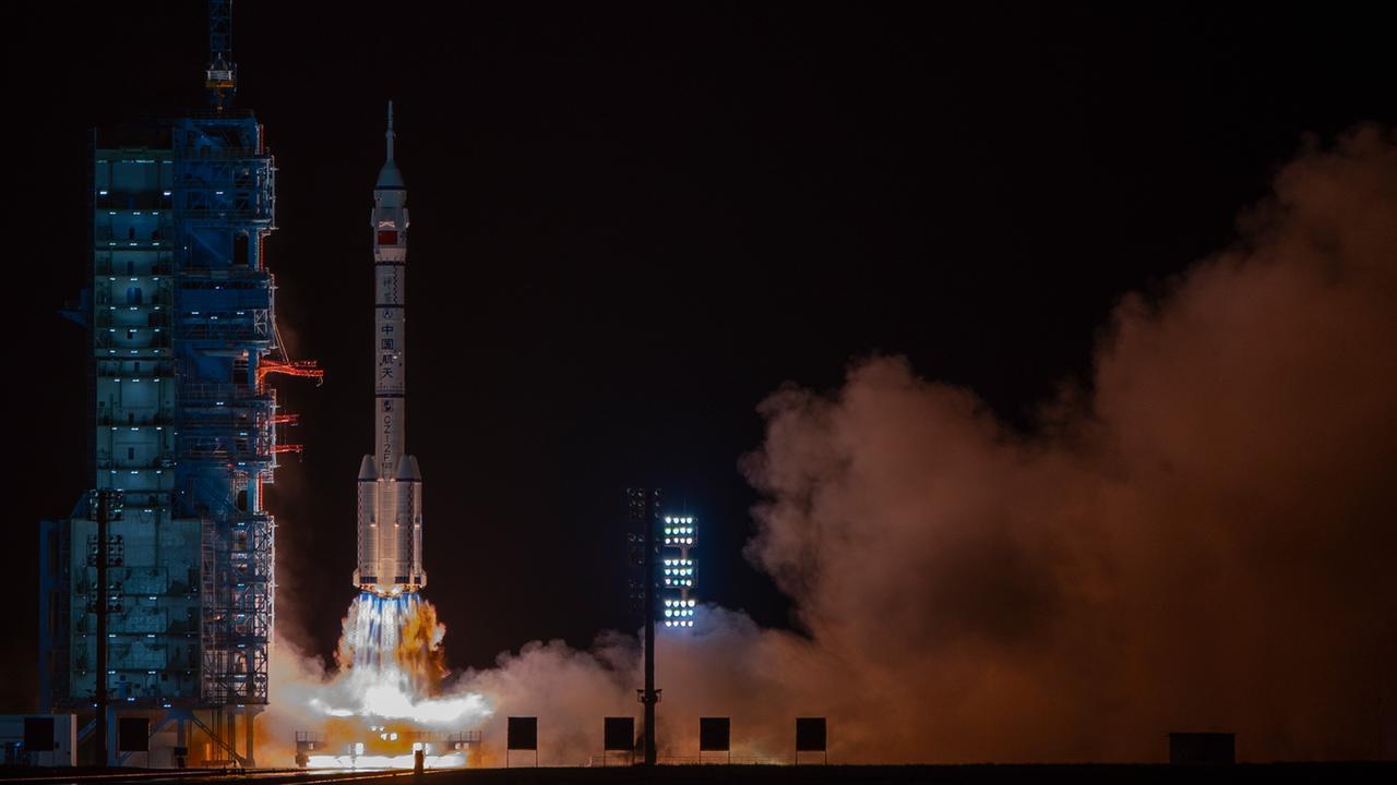 Das Bild zeigt den Start einer Trägerrakete bei Nacht. Unter den Triebwerken sind ein Feuerschweif und große Rauchschwaden zu sehen.