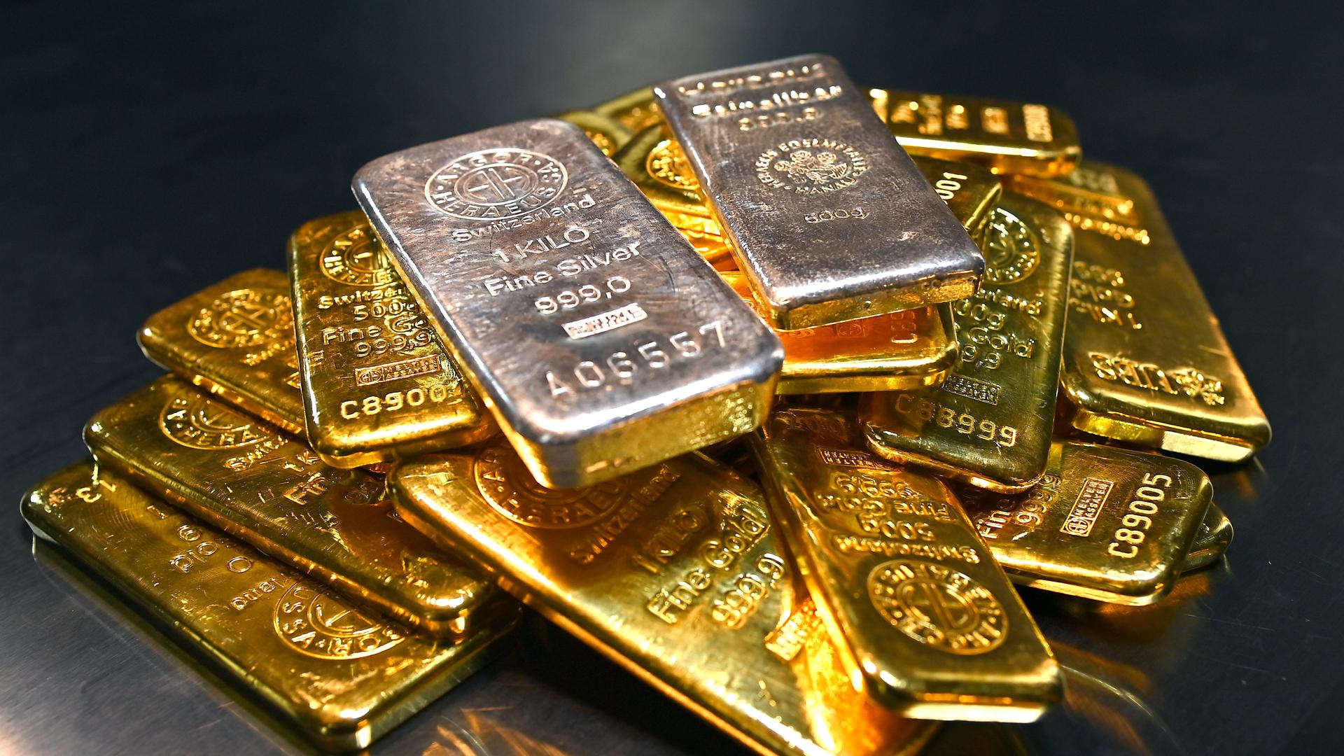 Goldbarren und Feinsilberbarren liegen übereinander.