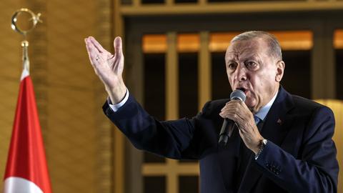 Der türkische Präsident Recep Tayyip Erdogan hält eine Ansprache. In der linken Hand hält er ein Mikrofon und gestikuliert.