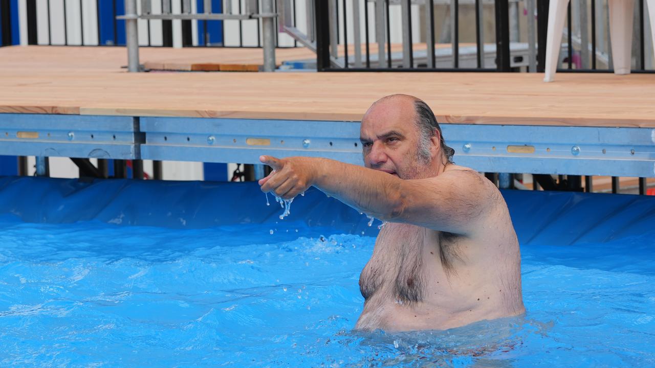 Intendant Matthias Lilienthal steht im Wasser des öffentlichen Schwimmbeckens vor der Volksbühne am Rosa-Luxemburg-Platz.