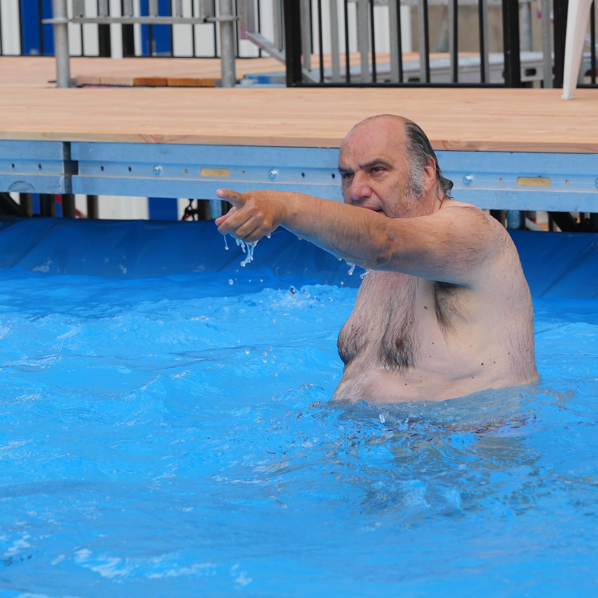 Intendant Matthias Lilienthal steht im Wasser des öffentlichen Schwimmbeckens vor der Volksbühne am Rosa-Luxemburg-Platz.