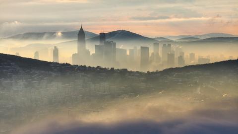 Über Istanbul liegt am Morgen eine Nebelschicht, dazwischen schauen Gebäude hervor.