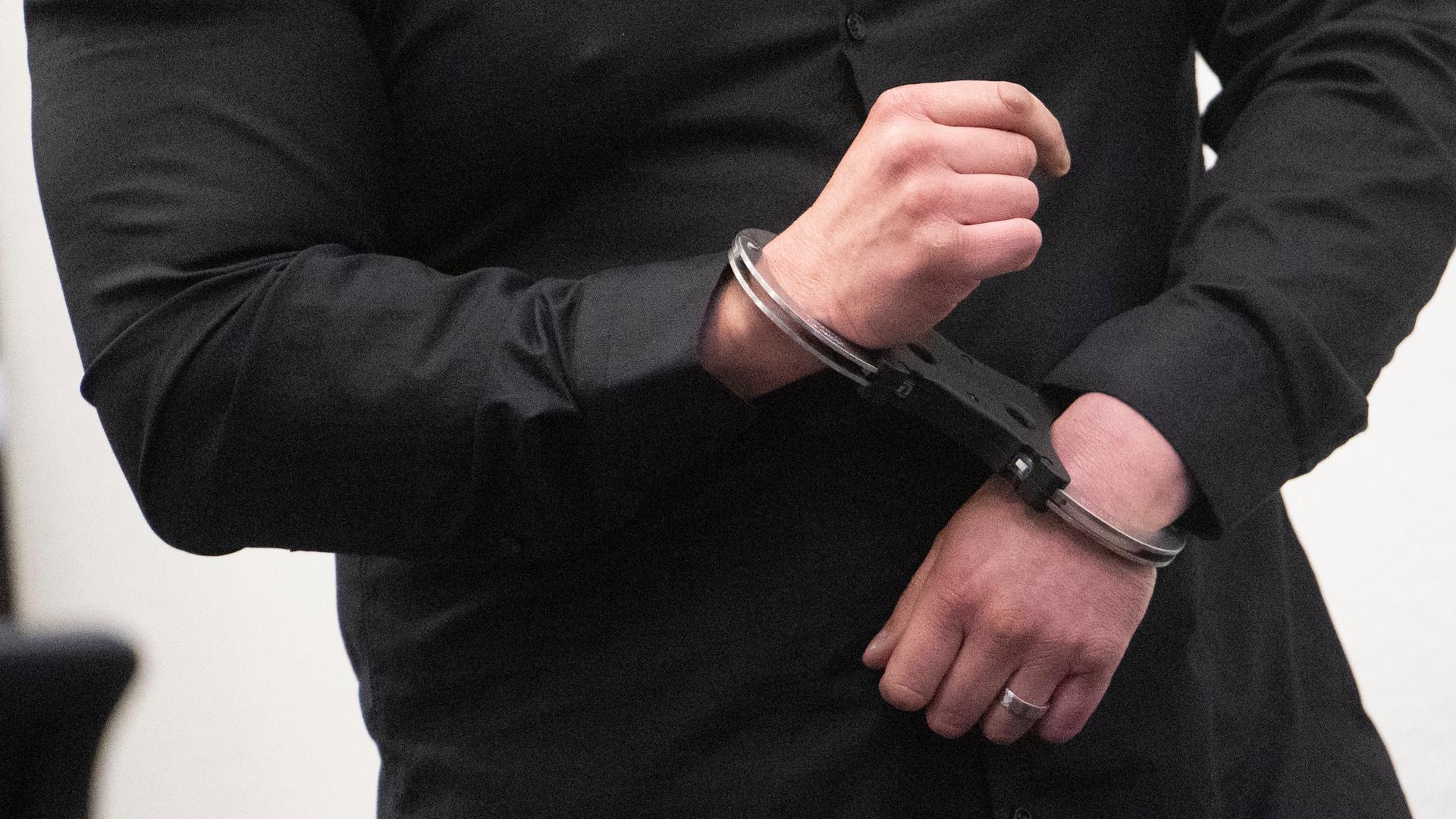 Stuttgart: Ein Angeklagter steht in Handschellen vor der Urteilsverkündung im Prozess wegen Mordes an zwei jungen Frauen in einem Saal des Landgerichts.