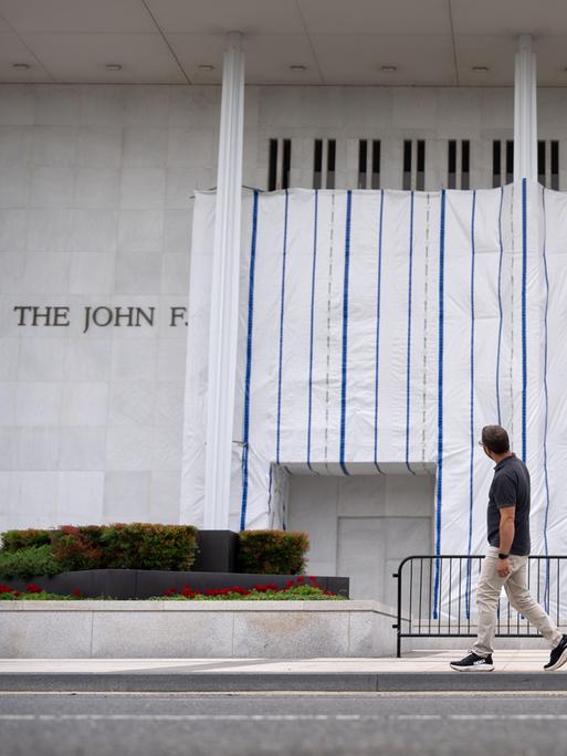 Besucher gehen am Freitag, dem 19. Juni 2026, in Washington am John F. Kennedy Center for the Performing Arts vorbei, dessen Schild weiterhin mit einer Plane abgedeckt ist. 