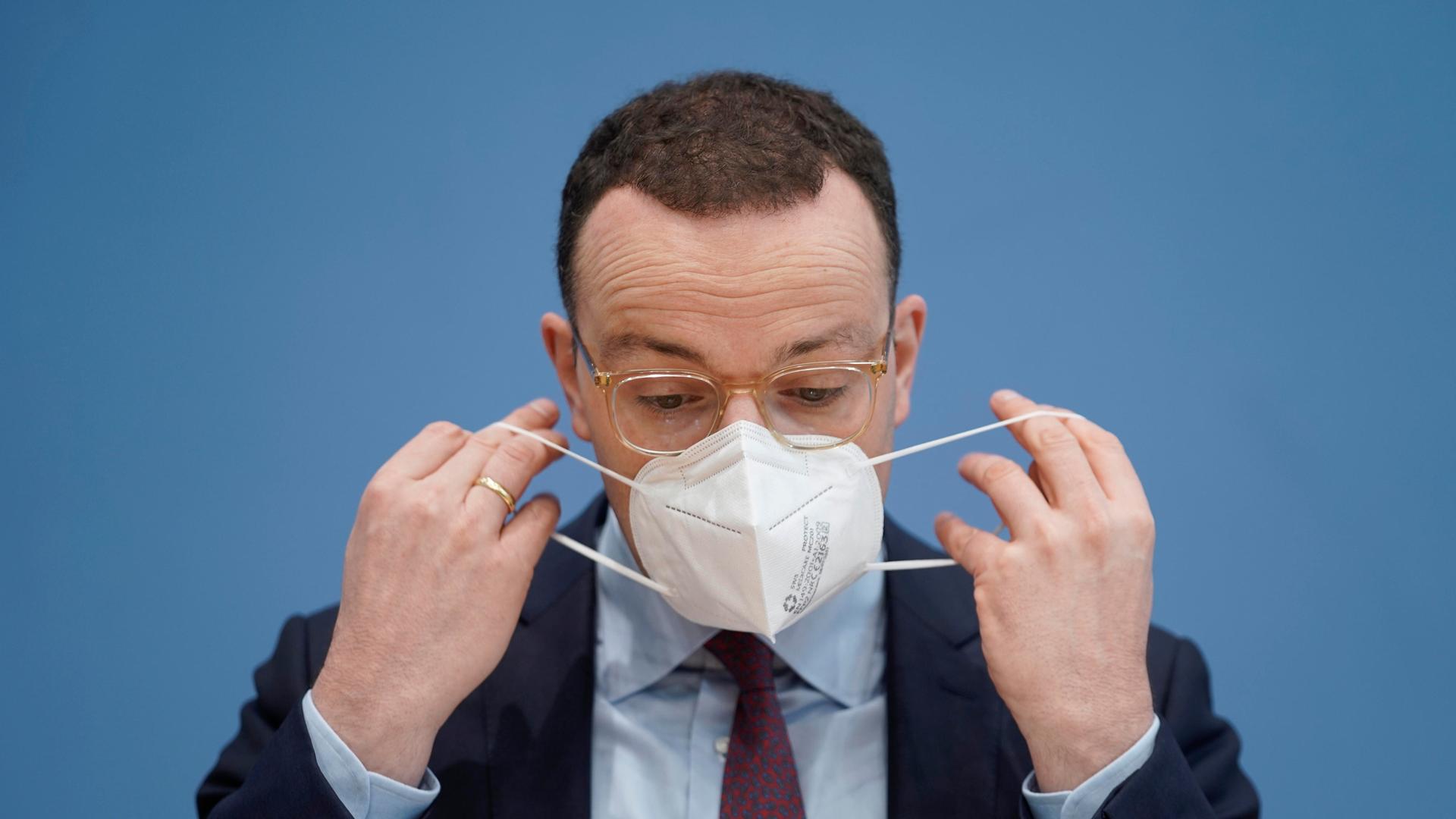 Der ehemalige Bundesgesundheitsminister Jens Spahn setzt sich bei der Bundespressekonferenz eine FFP2-Maske auf. (26.11.2021)