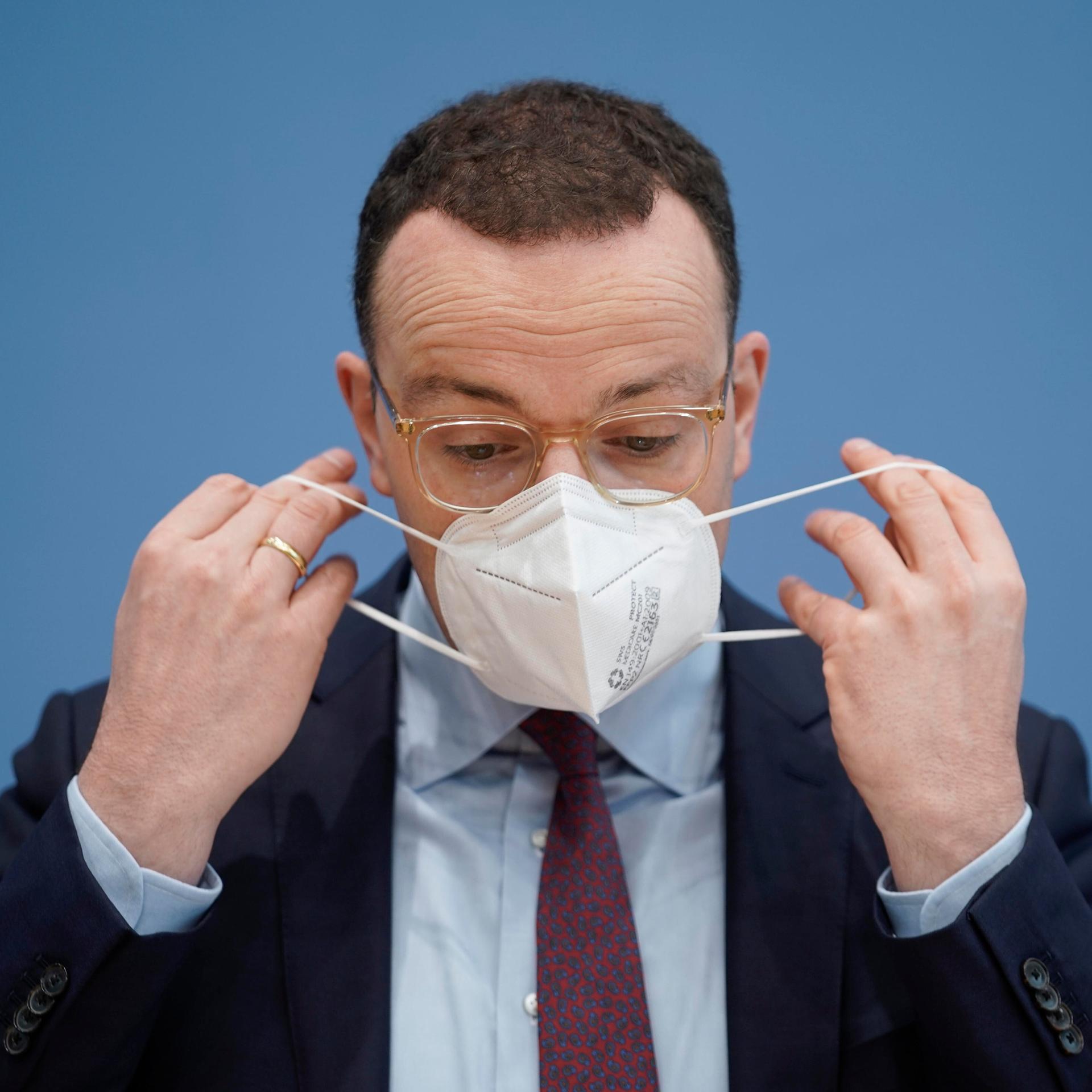 Bundesgesundheitsminister Jens Spahn setzt sich bei der Bundespressekonferenz eine FFP2-Maske auf. (26.11.2021)
