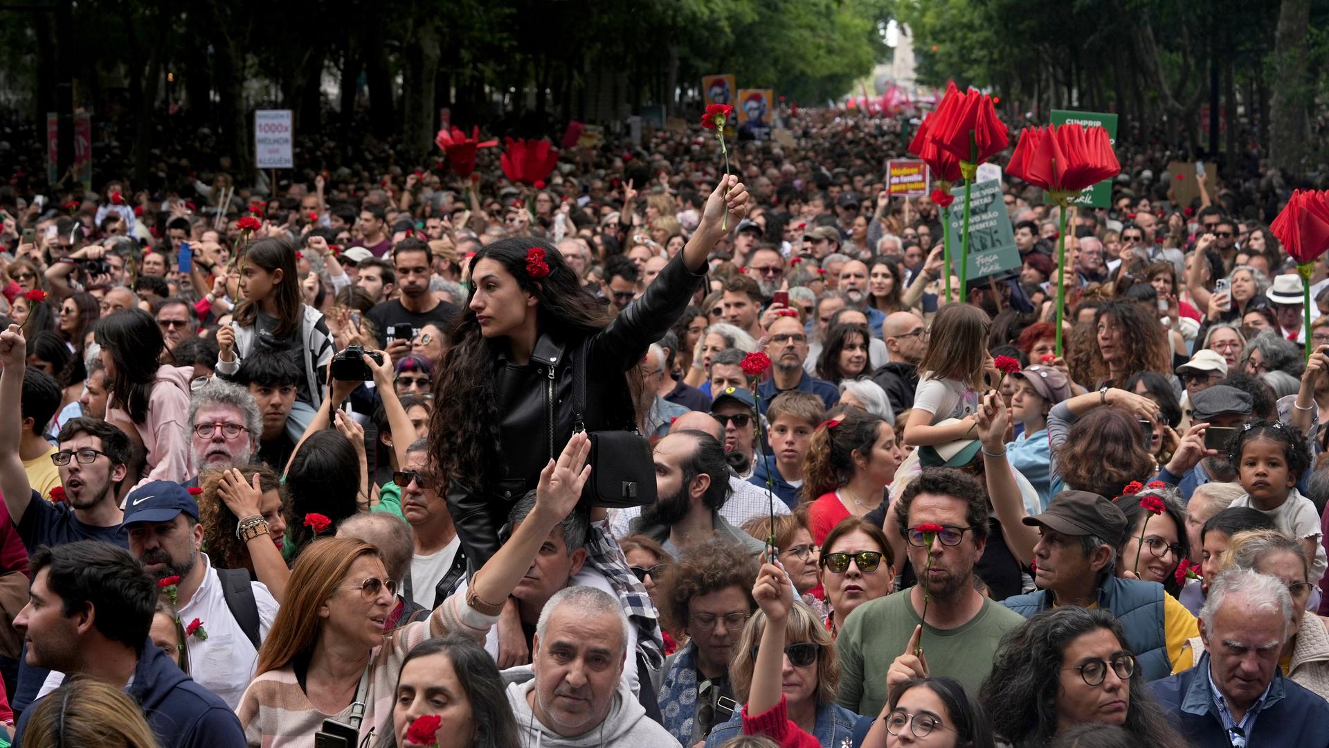 Tausende Demonstranten feiern in Lissabon die "Nelkenrevolution" von 1974. Viele tragen rote Nelken.
