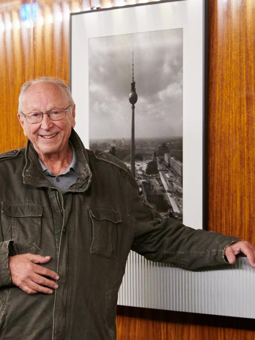 Thomas Billhardt, Fotograf, steht vor seinen historischen Bildern im Berliner Fernsehturm.
