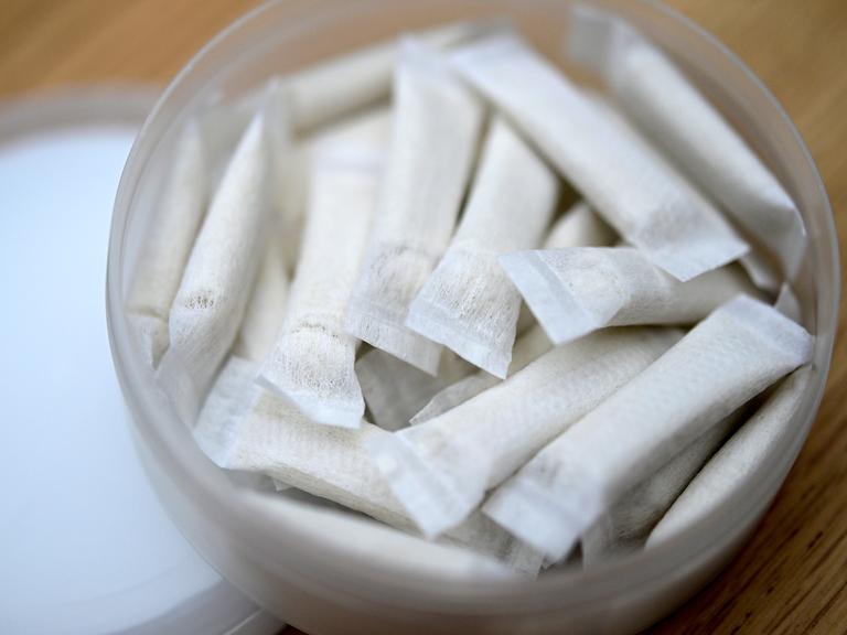 Eine Dose mit kleinen weißen Nikotinbeuteln auf einem Tisch (Symbolbild)