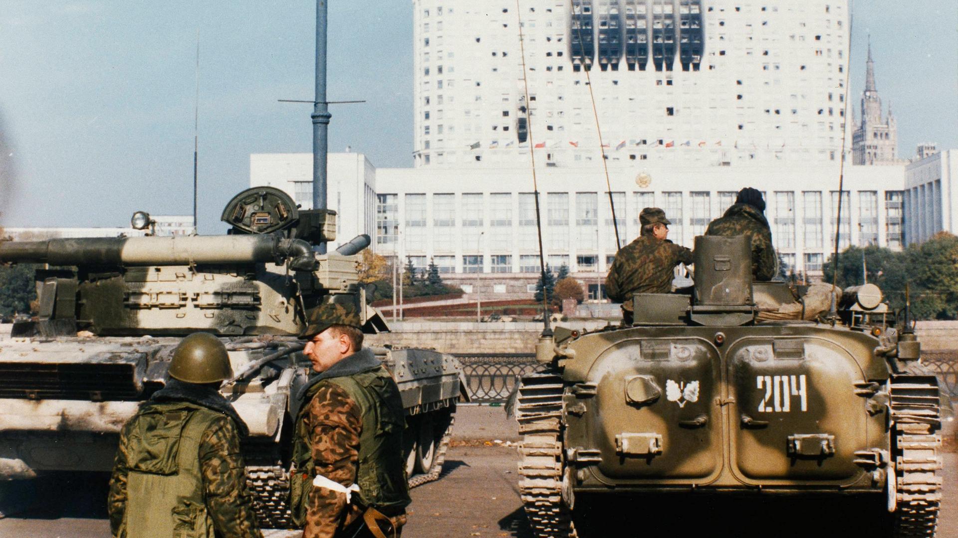 Eine Aufnahme von 1993 zeigt Soldaten vor der Rückansicht zweier Panzer vor einem hohen weißen Gebäude.