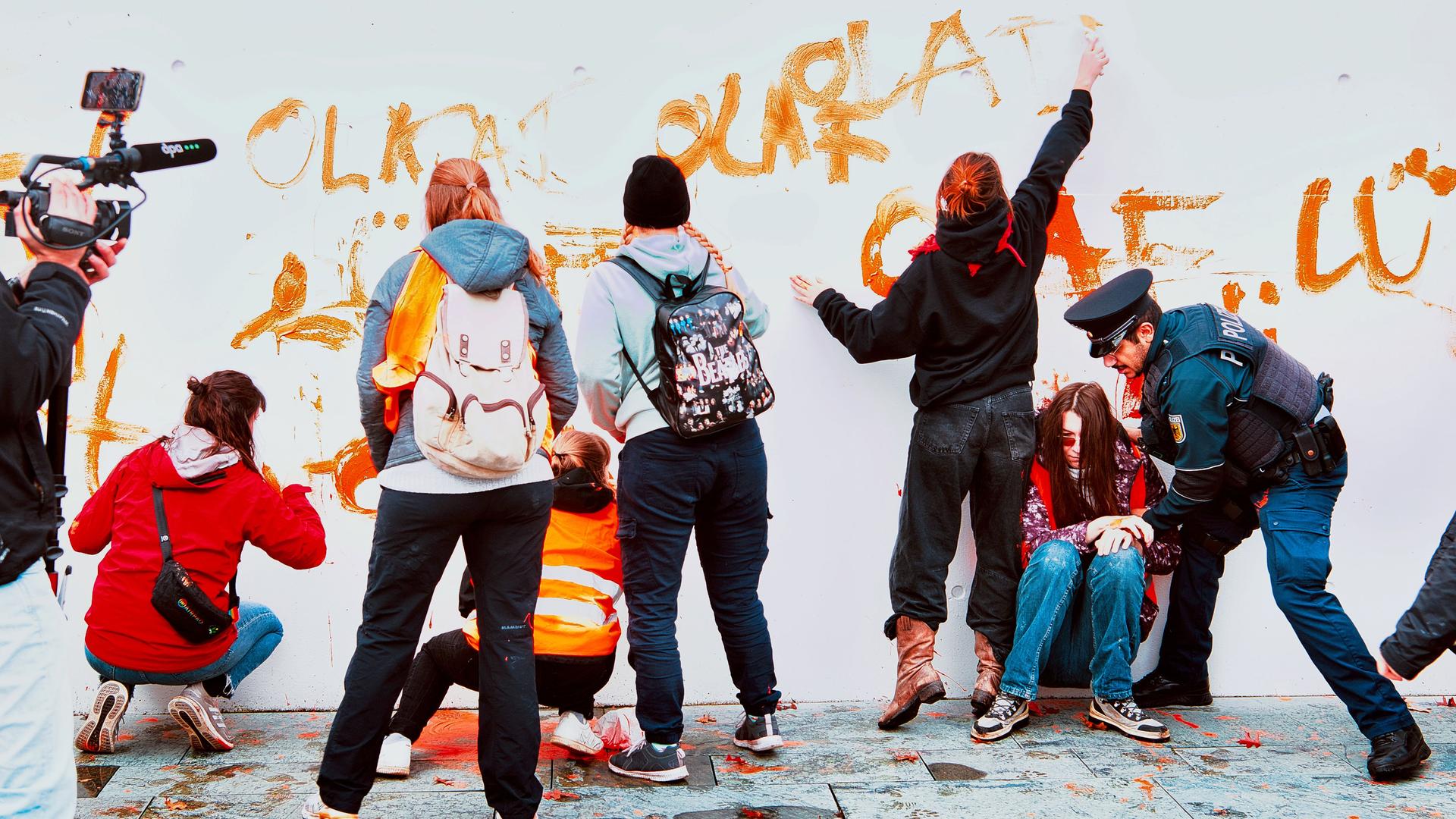 Aktivisten der Gruppe Letzte Generation werden vor dem Kanzleramt von Polizeibeamten gestoppt. Zuvor hatten sie eine Wand des Kanzleramtes mit dem Spruch "Olaf lügt" bemalt.