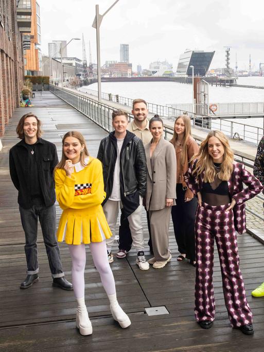 Auf dem Bild sind die sechs Acts für den deutschen Vorentscheid des ESC zu sehen. Sie lächeln in die Kamera. 