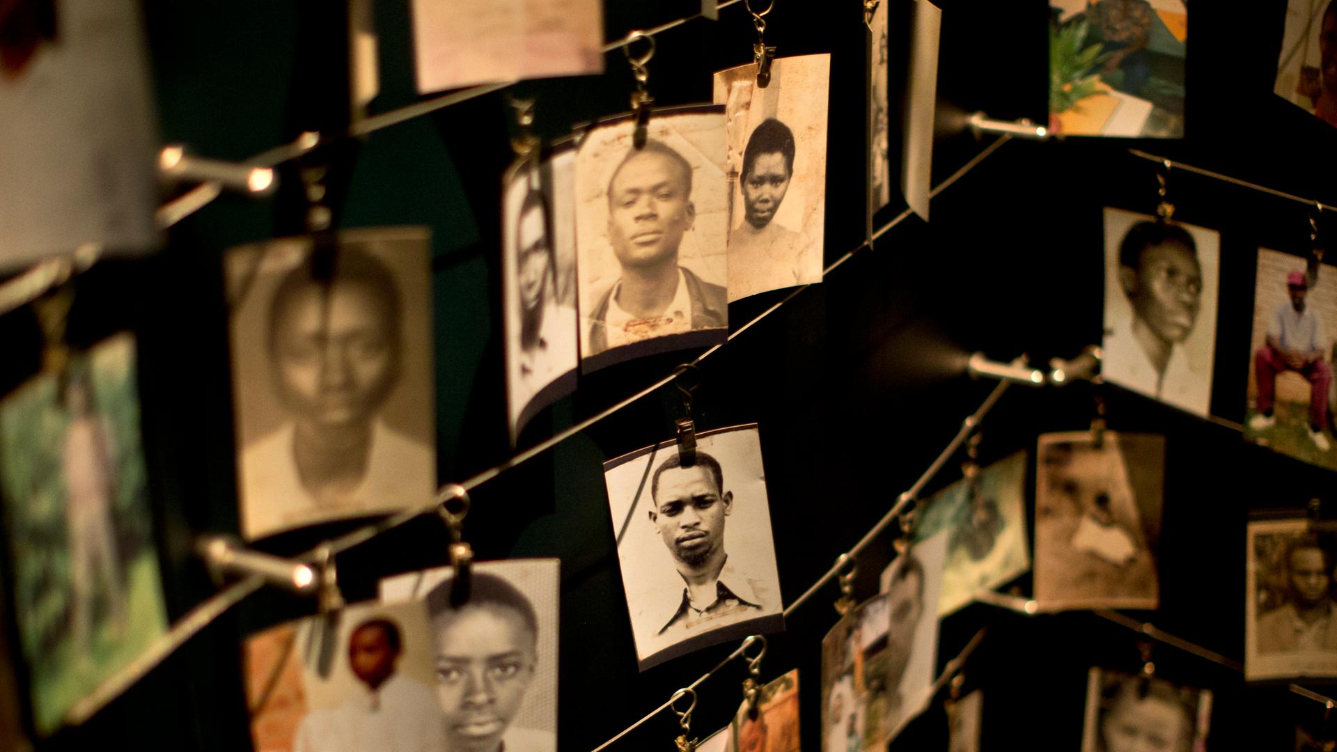 Fotos von Familienangehörigen sind im Kigali Genocide Memorial Centre in Kigali ausgestellt, die Fotos sind mit Klammern an drahtigen Leinen befestigt.