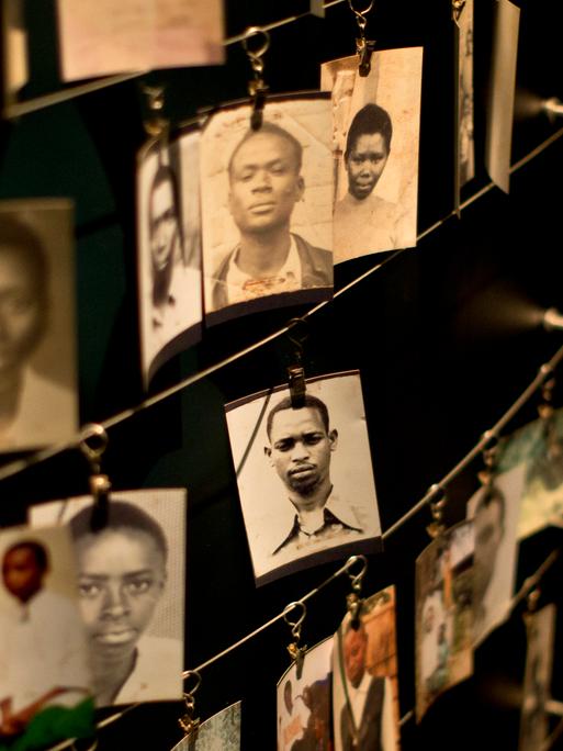Fotos von Familienangehörigen sind im Kigali Genocide Memorial Centre in Kigali ausgestellt, die Fotos sind mit Klammern an drahtigen Leinen befestigt.