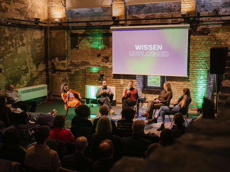 Gäste sitzen bei der Veranstaltung "Wissen unplugged" auf der Bühne