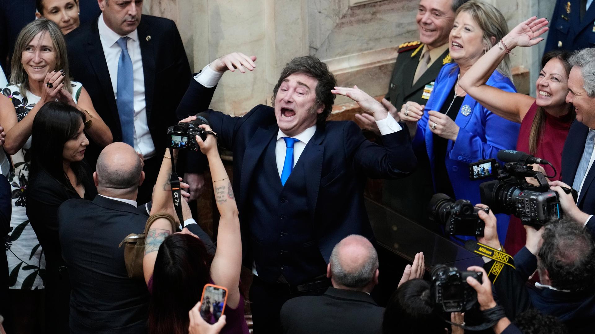 Der argentinische Präsident Javier Milei im Kongress umringt von Menschen, einige halten Kameras.