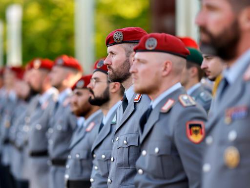 Soldaten stehen stramm beim Indienststellungsappell des Unterstützungskommandos der Bundeswehr auf der Hardthöhe in Bonn. Die Soldaten tragen ein rotes Barett und graue Uniformen.