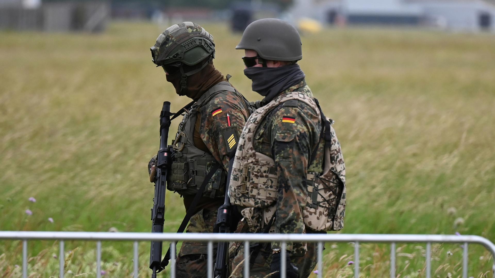 Soldaten der Bundeswehr gehen am Luftwaffenstützpunkt der Bundeswehr in Jagel durch hohes Gras. Soldaten der Bundeswehr gehen am Luftwaffenstützpunkt der Bundeswehr in Jagel durch hohes Gras.