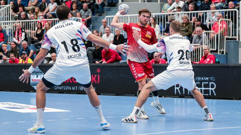 Zwei Spieler des ukrainischen Handballclubs Motor Saporischschja (v.l.: Carlos Molina Cosano und Oleksii Tomashevskyi) verteidigen im Spiel der 2. Bundesliga gegen einen Spieler von TuSEM Essen (Jonas Ellwanger), der zum Wurf ansetzt. 