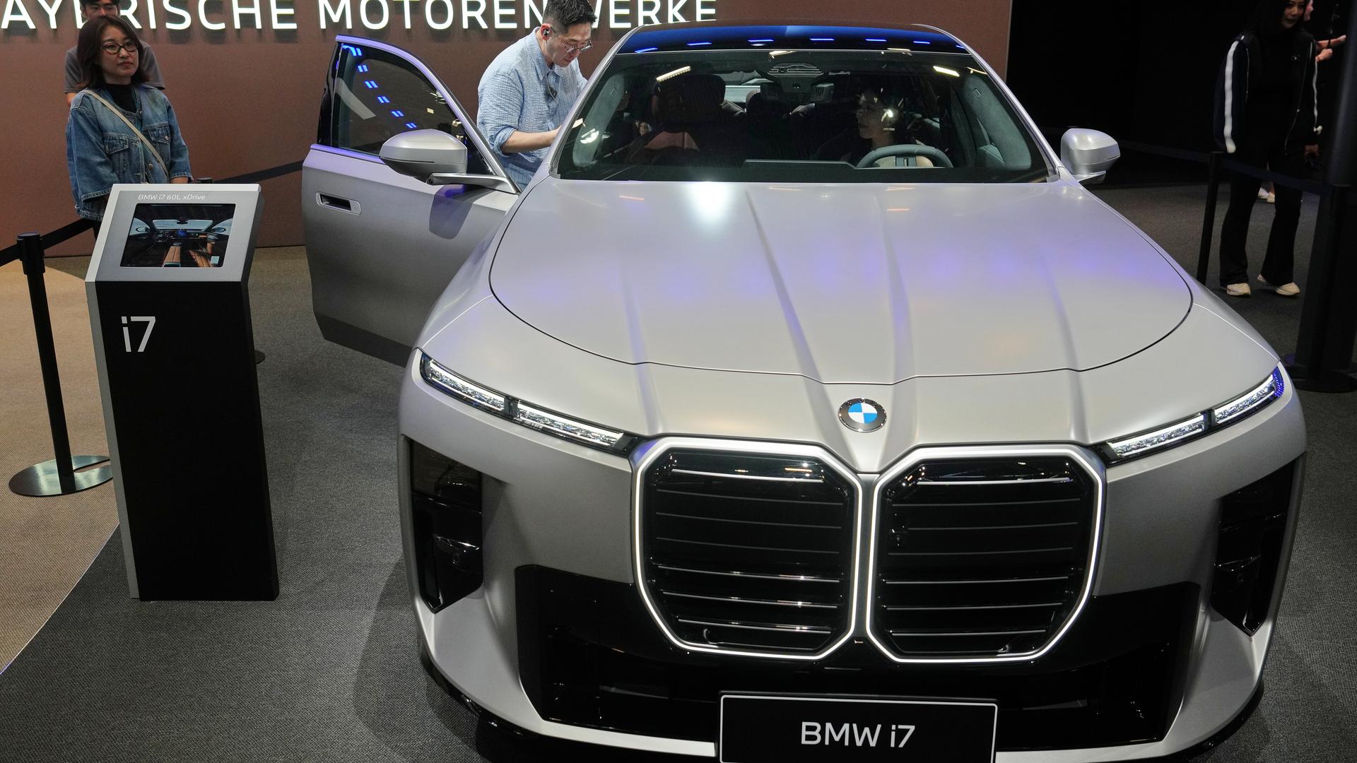Das Foto zeigt Besucher der internationalen Automesse in Peking. Sie betrachten das Modell BMW i7.