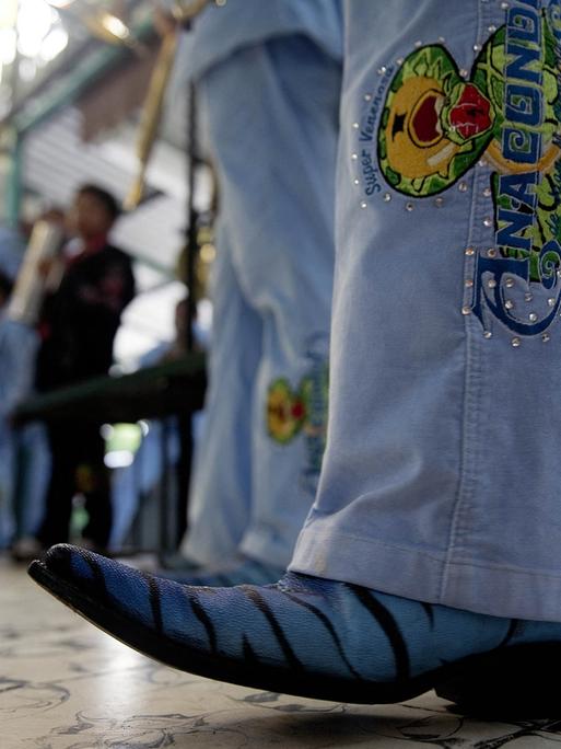 Ein Besucher eines Narcocorridos-Konzerts in Jeans und auffälligen Cowboy-Stiefeln. 